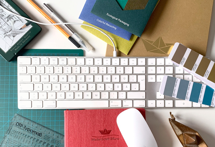Tastatur. Stifte. Papiere. Eine Maus. Das sind einige Werkzeuge eines Grafikdesigners.